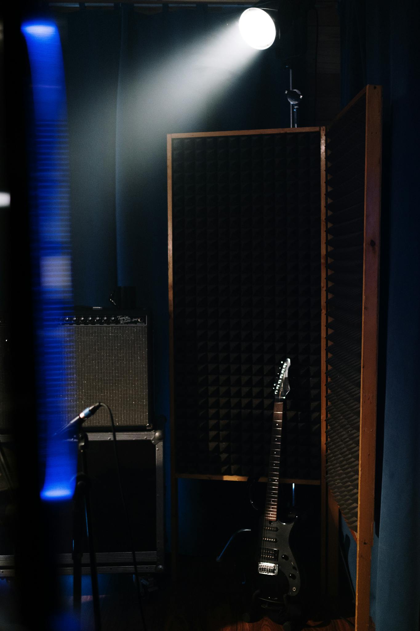Electric guitar in a dimly lit recording studio with audio equipment.